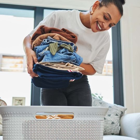 Neatly folded clothing is so satisfying. Shot of a young woman packing away clean laundry